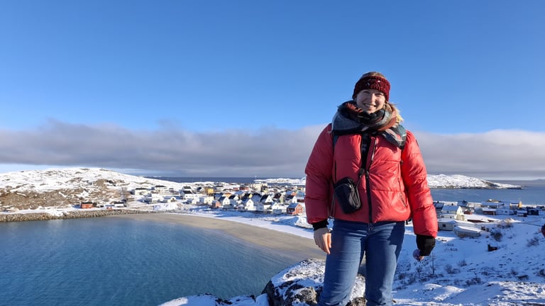 a woman standing in the arctic with a beautiful view