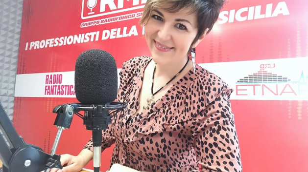 a woman in a leopard print blouse and a microphone