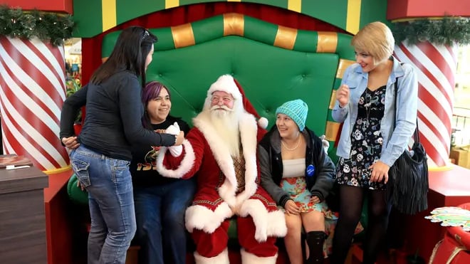 Joulupukki jakaa lahjoja ja poseeraa valokuvassa iloisten vieraiden kanssa Nature Dream Days pikkujo