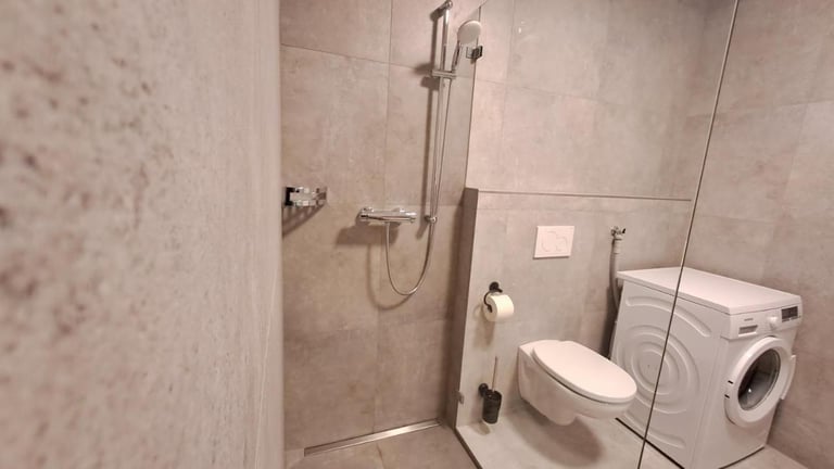 a bathroom with a washing machine and a washing machine