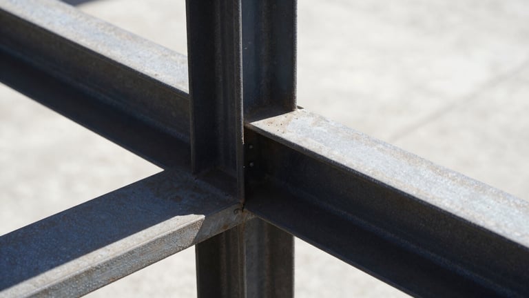 Extreme close-up of structural steel connection with high-contrast shadows, raw metal texture under harsh direct sunlight, stark industrial photography.