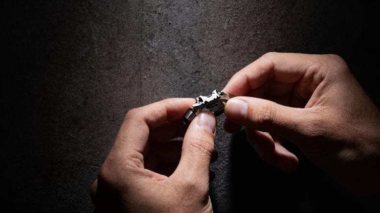 Close-up of human hands with short, clean nails, gently adjusting the unconventional, textured crown of a YOUR TIME TO FLY watch. Harsh, high-contrast directional spotlighting, deep dramatic shadows, against a dark, raw concrete backdrop. Panoramic 21:9 frame.