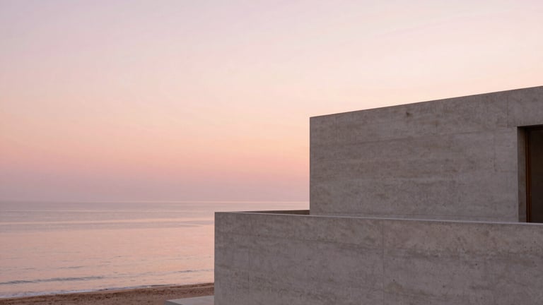 Wide panoramic shot of a minimalist concrete villa overlooking a calm sea at sunset, warm pink sky, soft architectural shadows, 35mm photography