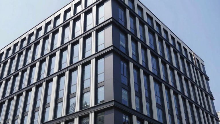 Wide-angle environmental shot of a secured modern commercial building, clean architectural detail, crisp daylight, 35mm