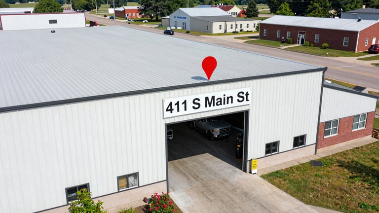 Wide aerial shot of Sheridan, Indiana, with a clear pin marking 411 S Main St, indicating the service area for Vanguard Garage Door's Repairs Crew, bright natural daylight, crisp focus.