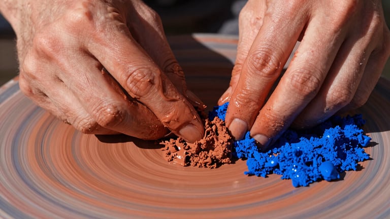 Extreme close-up of raw pigment textures in deep terracotta and cobalt blue, hands shaping wet clay in the studio, hard direct sunlight, sharp shadows, 35mm lens