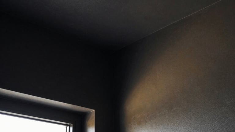 Extreme close-up of a perfectly sharp, clean interior corner where two Gyproc walls meet, painted in a deep charcoal color, with a subtle golden reflection from an unseen light source. High-contrast, geometric framing, architectural photography.