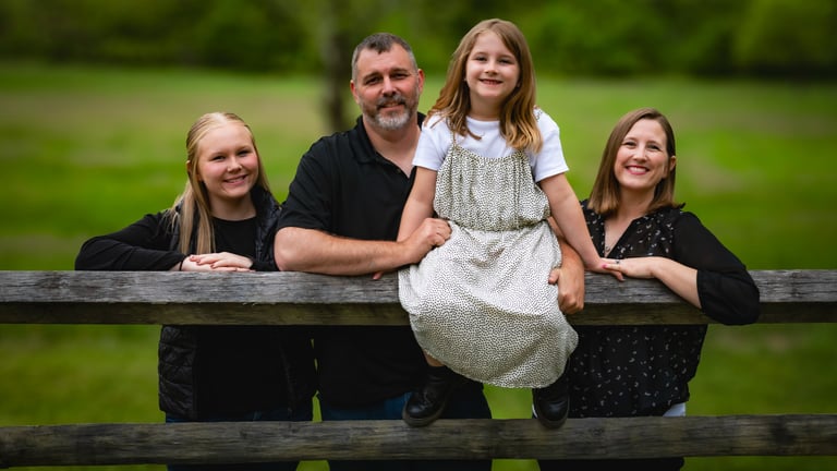 Family portrait of parents and children leaning on a rustic wooden fence. Athens_Ohio_family.jpg