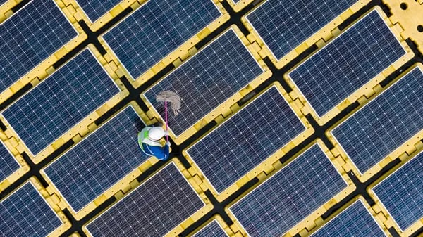 Fotografía desde arriba de personal capacitado con equipo de protección realizando limpieza en panel