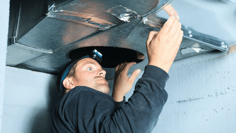 a man in a black hat and a hat on a metal pipe