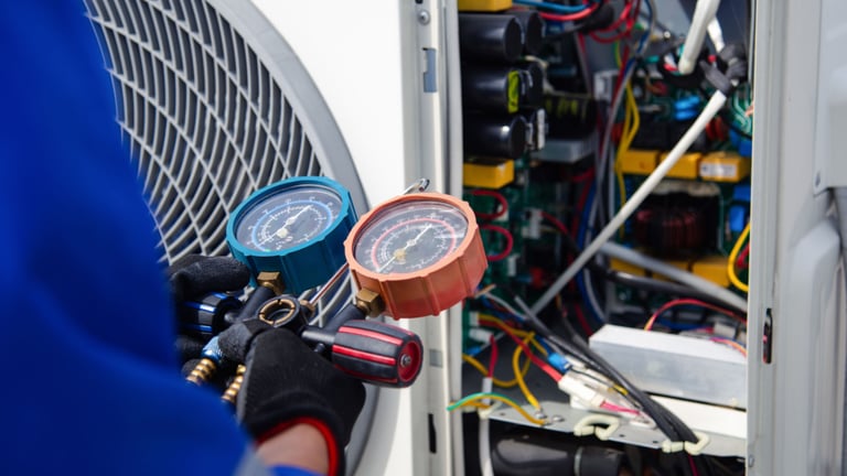 a man in a blue shirt and gloves holding a gauge