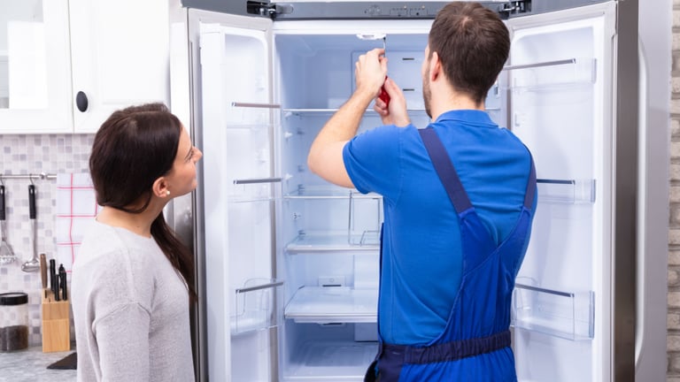 a man and woman standing in front of a refrigerator