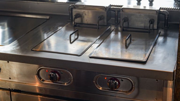 a stove top with three burners and a sink
