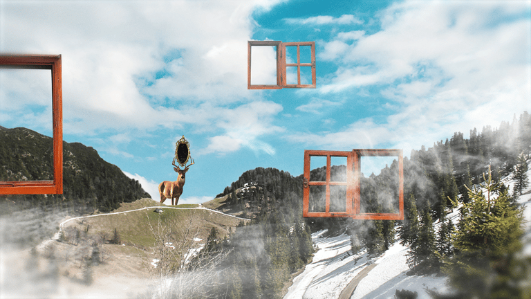 a deer standing on a mountain top with a mirror between its horns.