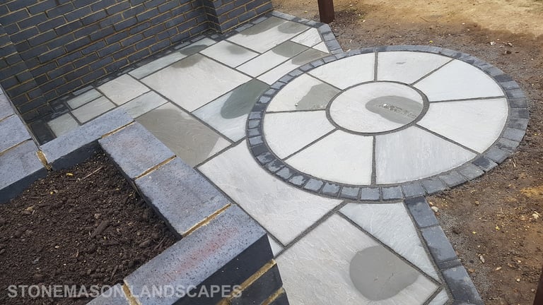 Blue Perforated Brick Wall Planter With Grey Sandstone Circle & Patio Paving & Wooden Pergola