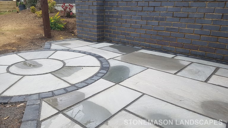 Blue Perforated Brick Wall Planter With Grey Sandstone Circle & Patio Paving & Wooden Pergola