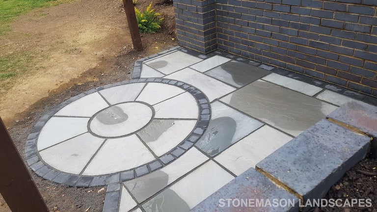 Grey sandstone circle paving slabs with charcoal edging