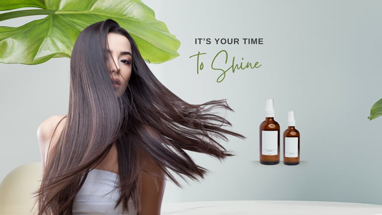 A woman with long shiny brown hair posing next to two amber glass bottles of organic hair serum.