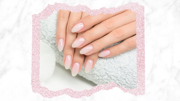 Elegant nude ombre almond shaped nails over a soft spa towel with a marble background.