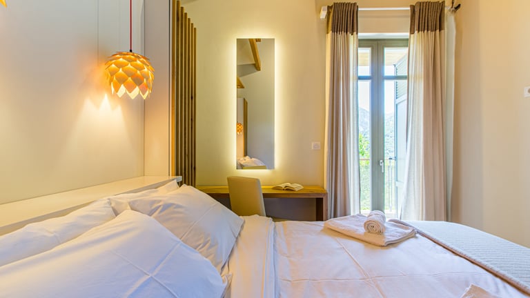 Cozy bedroom corner with hanging lamp and soft lighting at Villa Skyphos