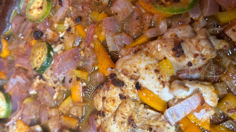 Baked chicken and vegetables on a baking pan just out of the oven.