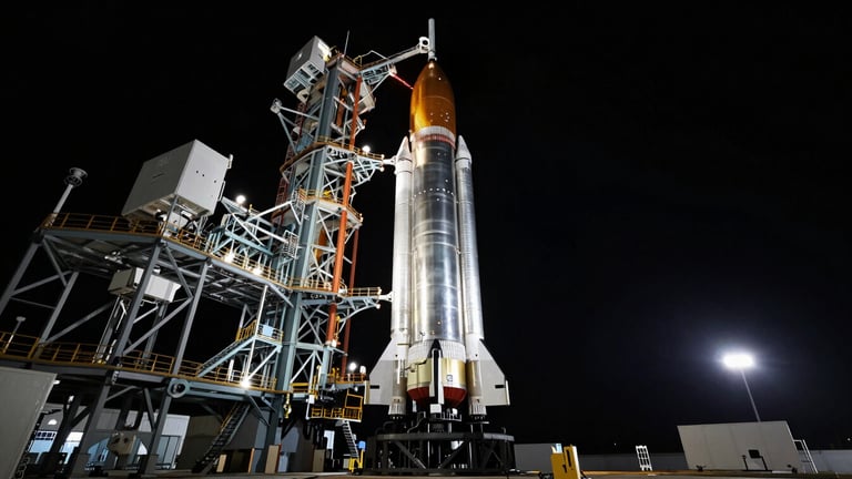 Wide-angle cinematic capture of a massive stainless steel rocket booster on the launchpad at dusk, dramatic cold rim lighting, deep black sky.