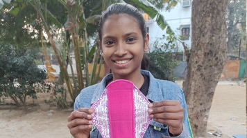 Girl holding up a Hanaru reusable sanitary napkin