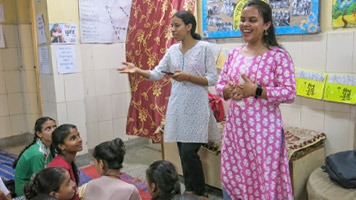 Ambassadors Pooga G and Priyanka standing at the front of a classroom