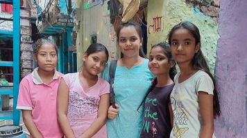 Priyanka standing in the centre of four girls in a slum area in Delhi.