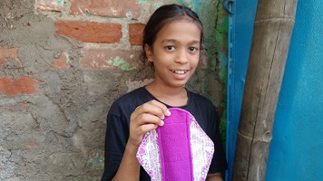 Girl holding up a reusable sanitary napkins.