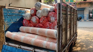 Large van with wooden sides delivering rolls of material