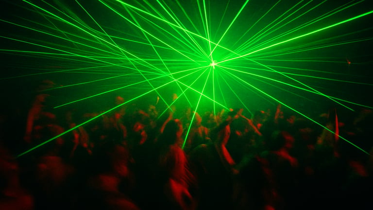 Dark Las Vegas warehouse club, intense green laser grid, crowd of dancers in motion blur