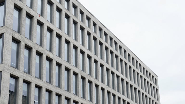 Sharp architectural photograph of a modern Swiss office building in Flaach, clean concrete and glass facade, bright overcast daylight, desaturated cool tones with a subtle red accent flag, 35mm