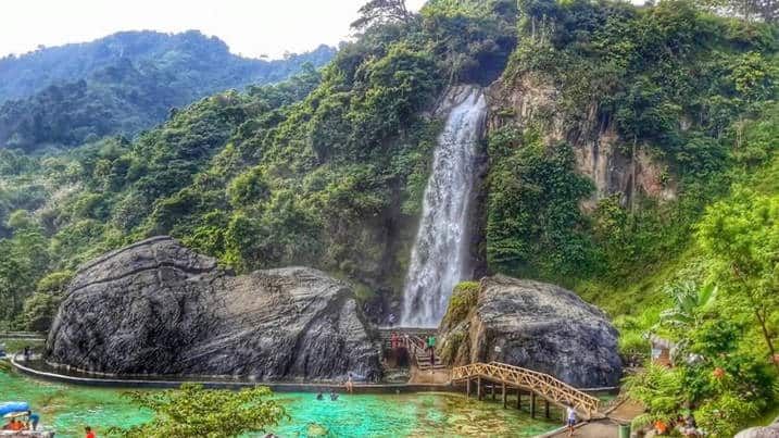 Air terjun Curug Bidadari setinggi 55 meter mengalir deras di Sentul Paradise Park, dikelilingi bebatuan besar dan jembatan i