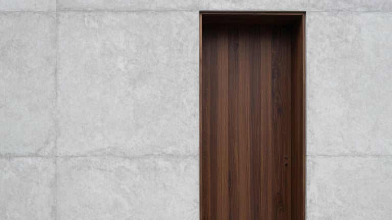 Straight-on architectural detail shot of custom dark oak joinery meeting a raw light-gray concrete wall, soft overcast daylight.