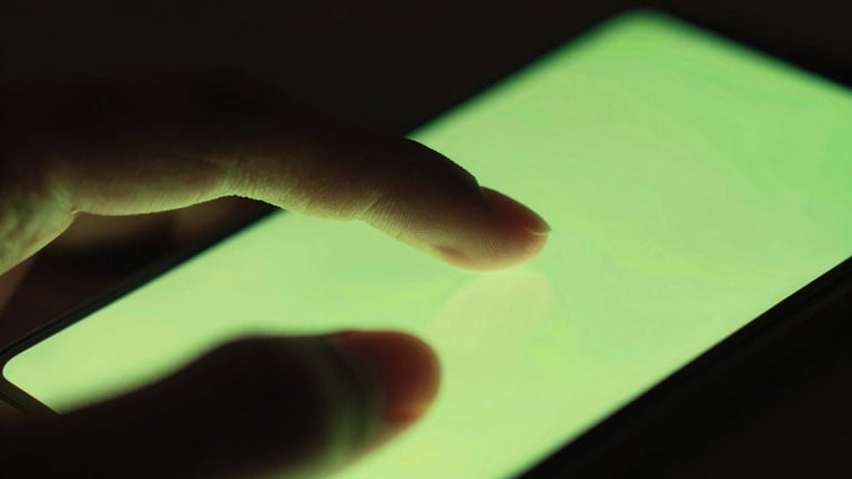 Extreme close-up macro of fingers interacting with a glowing Android screen, vibrant neon cyber lime screen-glow casting onto hands, dark moody ambient lighting, shallow depth of field