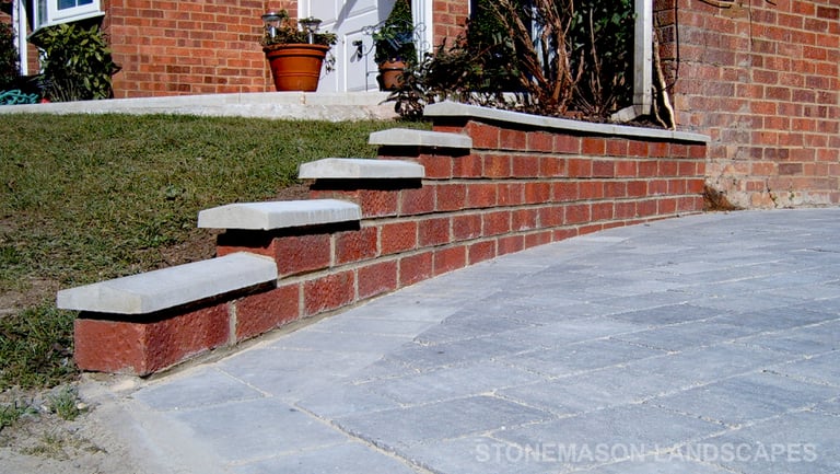 Premium grey block paver driveway and red brick wall with white coping