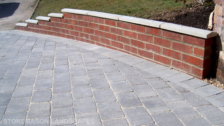 Premium grey block paver driveway and red brick wall with white coping
