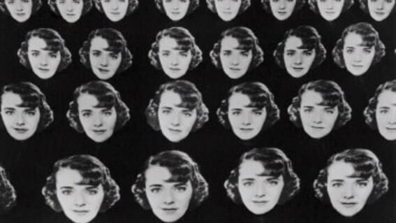 Female dancers holding multiple giant Ruby Keeler face cutouts in a classic Berkeley formation.