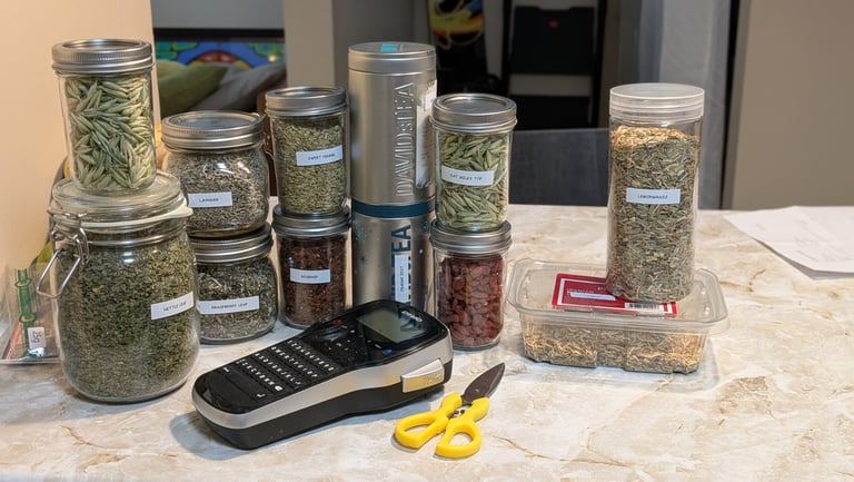 Open cardboard box containing several plastic bags filled with dried herbs and tea ingredients.