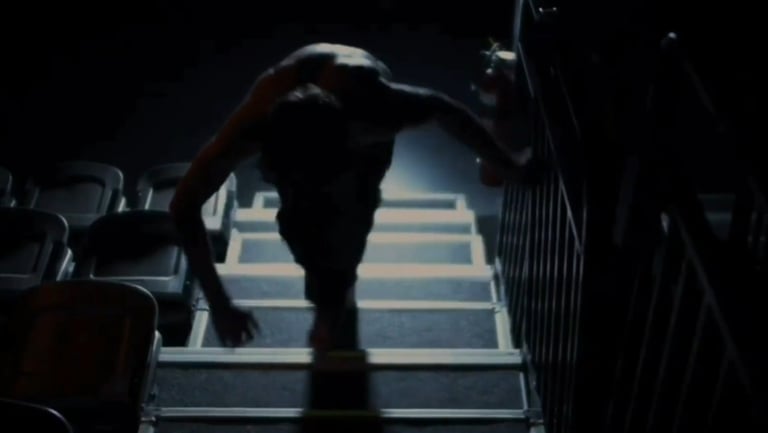a man walking up stairs in a darkened room