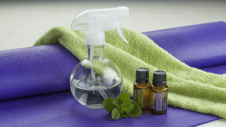 a bottle of essential oils and spray mat yoga