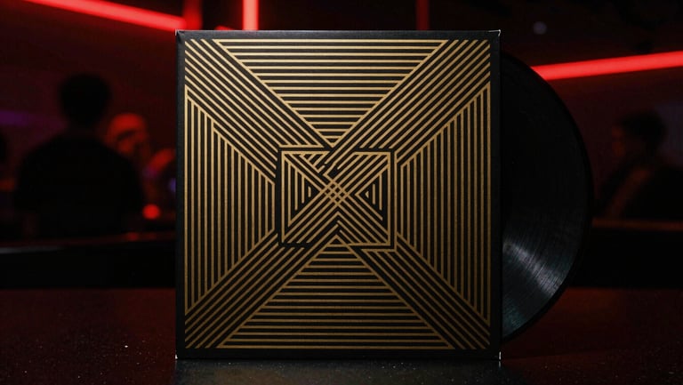 Dark minimalist vinyl record sleeve, gold metallic geometric pattern, high-contrast black background, atmospheric lighting