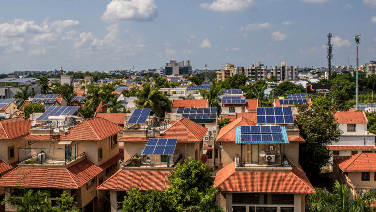 a cityscape of houses with solar panels on the roof