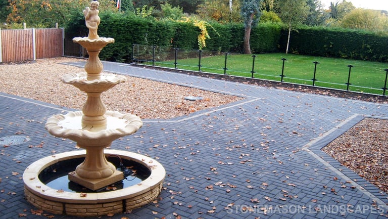 Charcoal standard block paving large patio and glass wall.