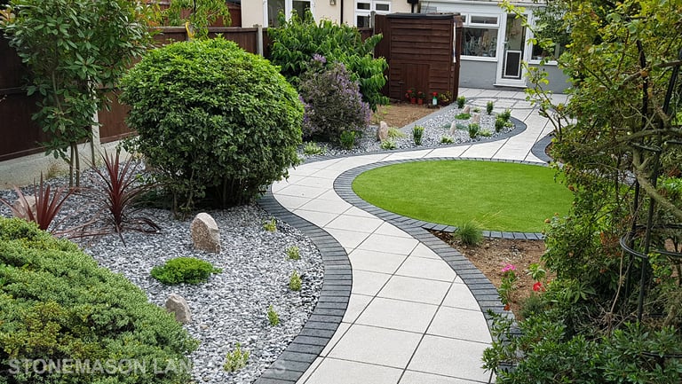 Patio with custom stone circle with aggregates and paving weaving through adventurous garden design