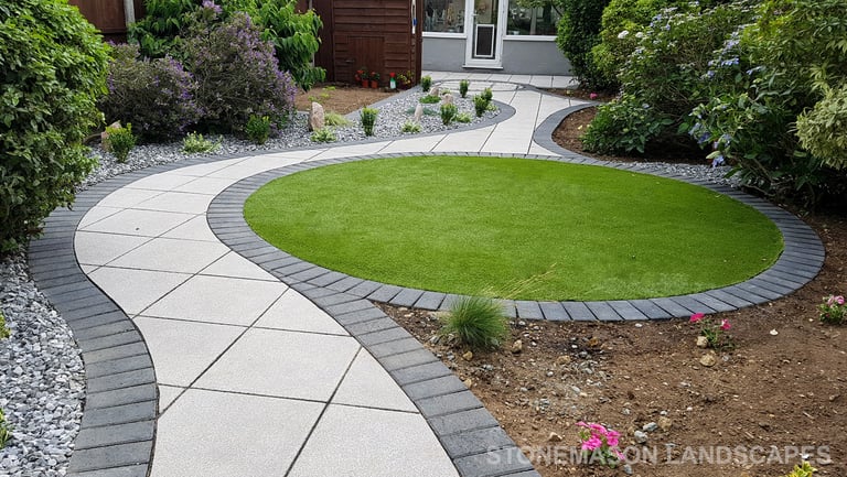 Patio with custom stone circle with aggregates and paving weaving through adventurous garden design