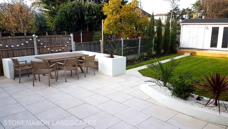 Modern chic raised porcelain patio with white rendered walls and planters
