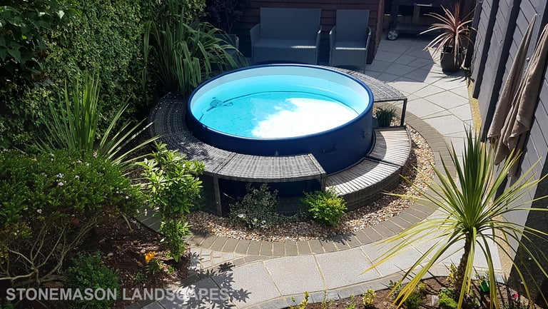 Small tropical garden with fanned paving slabs in circle around hot tub
