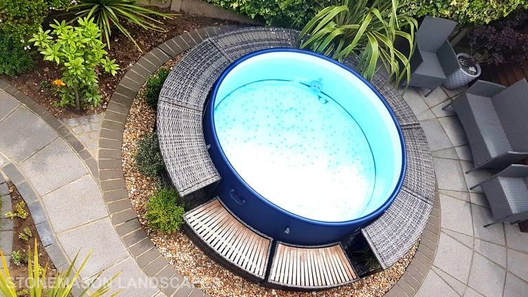 Small tropical garden with fanned paving slabs in circle around hot tub